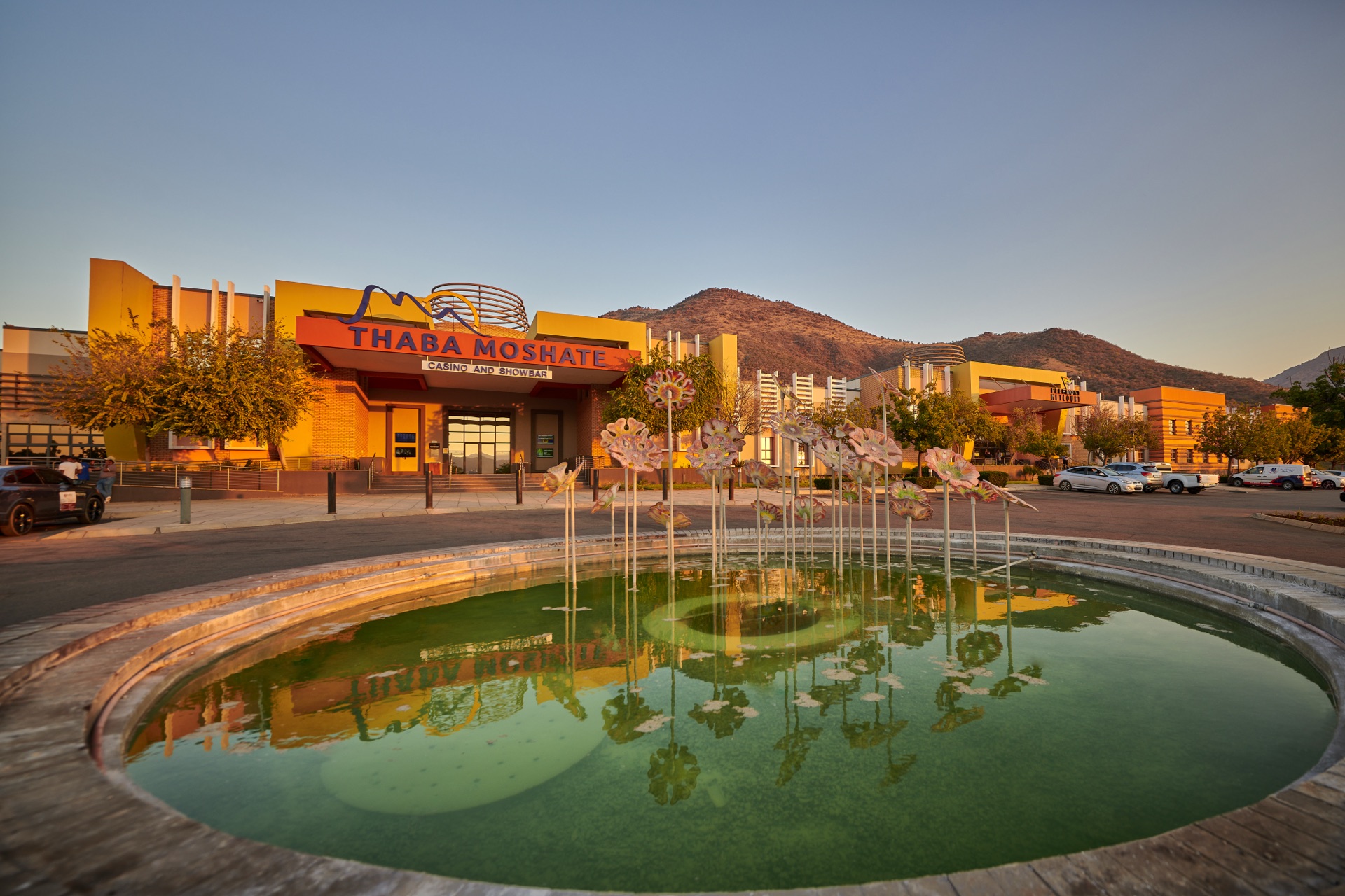 Golden exterior and fountain of the Thaba Moshate Casino and Showbar at sunset in Burgersfort