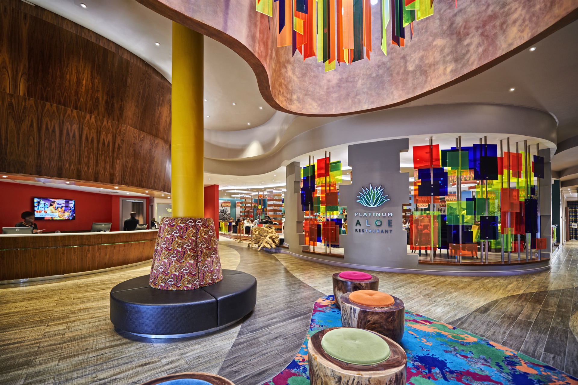 Hotel reception lobby with stained-glass feature wall and timber curves at Thaba Moshate, Burgersfort