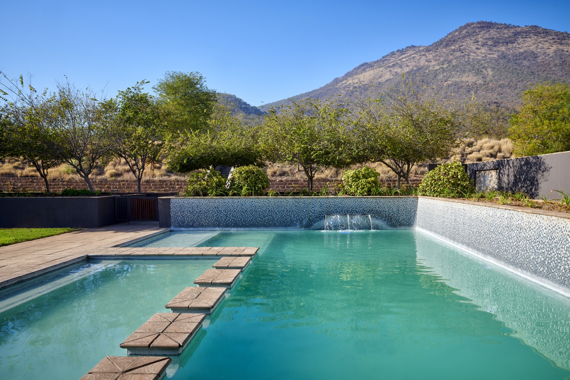 Tranquil outdoor swimming pool set against bushveld mountains at Thaba Moshate, Burgersfort