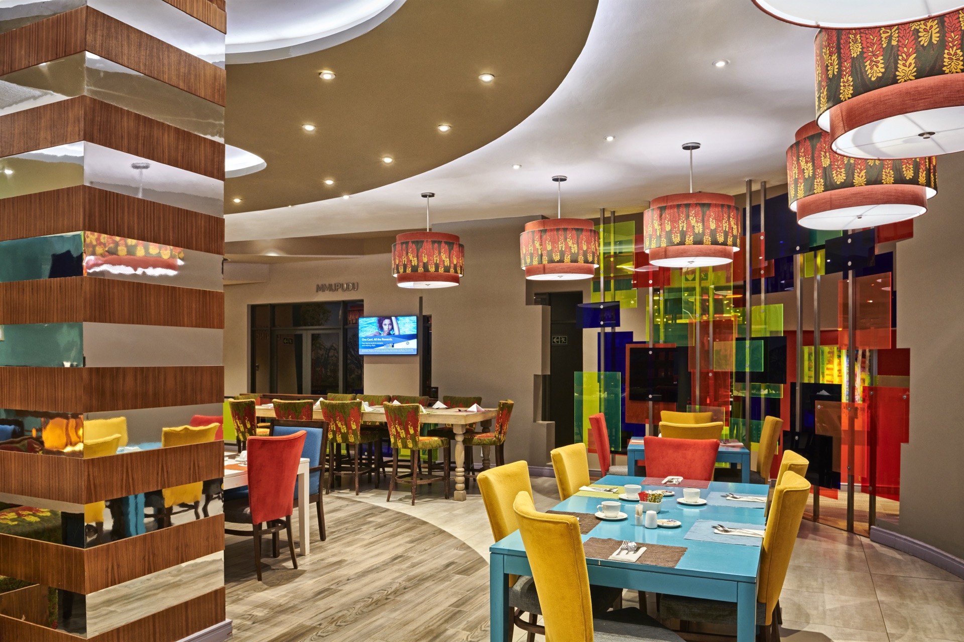 Restaurant dining area with bright pendant lights and coloured glass at Thaba Moshate, Burgersfort